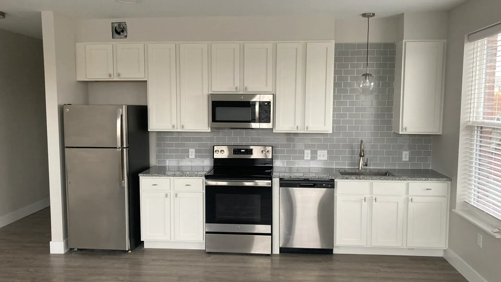Bright, modern kitchen with stainless steel appliances and white cabinetry.