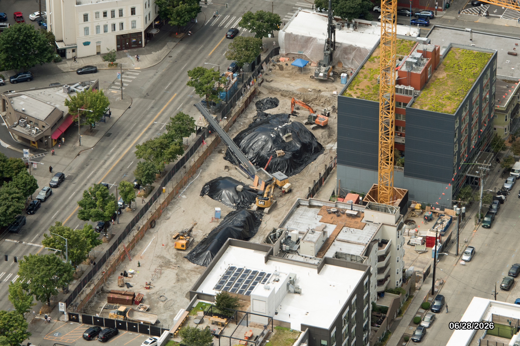 Aerial view of a construction site with construction equipment and machinery on a city block.