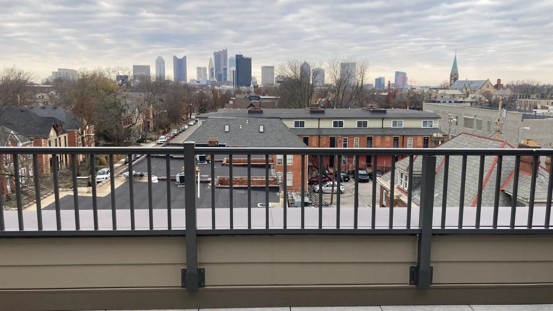 Rooftop view of a city skyline with residential buildings in the foreground.