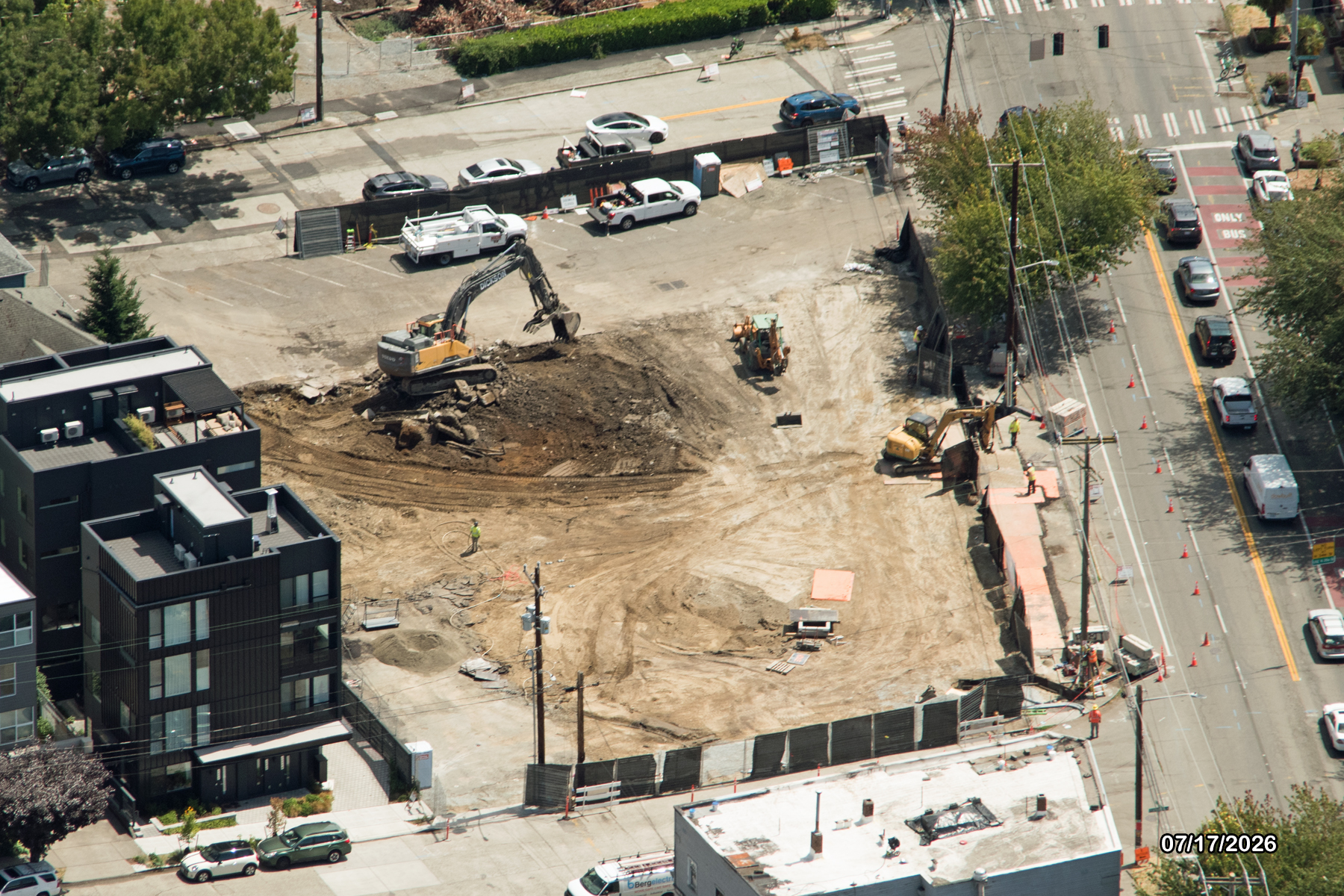 Aerial view of a construction site with heavy machinery and a cleared area surrounded by fencing.