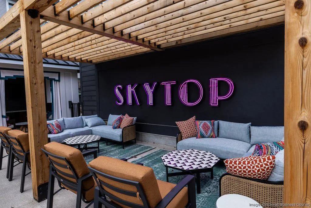 Outdoor lounge area with comfortable seating and a neon sign that says 'SKYTOP'
