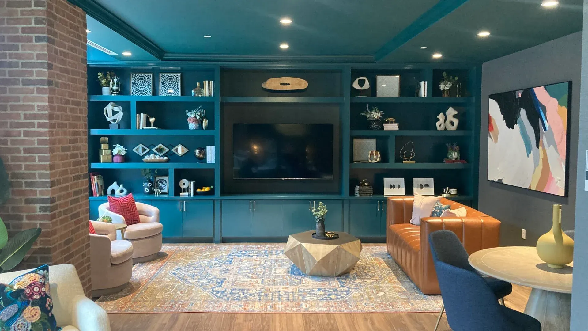 A modern communal living space with stylish seating, decorative shelves, and a coffee table.