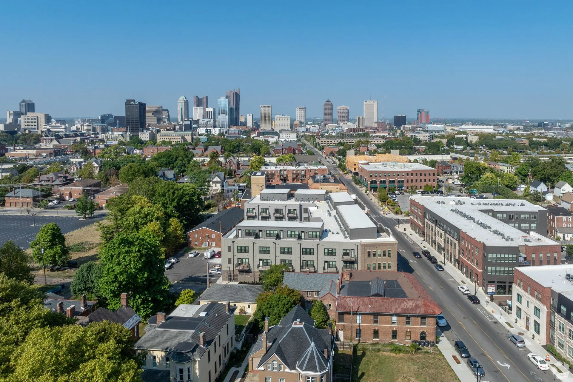 Aerial view of a sprawling urban area, showcasing a mix of residential and commercial buildings with a skyline in the background.