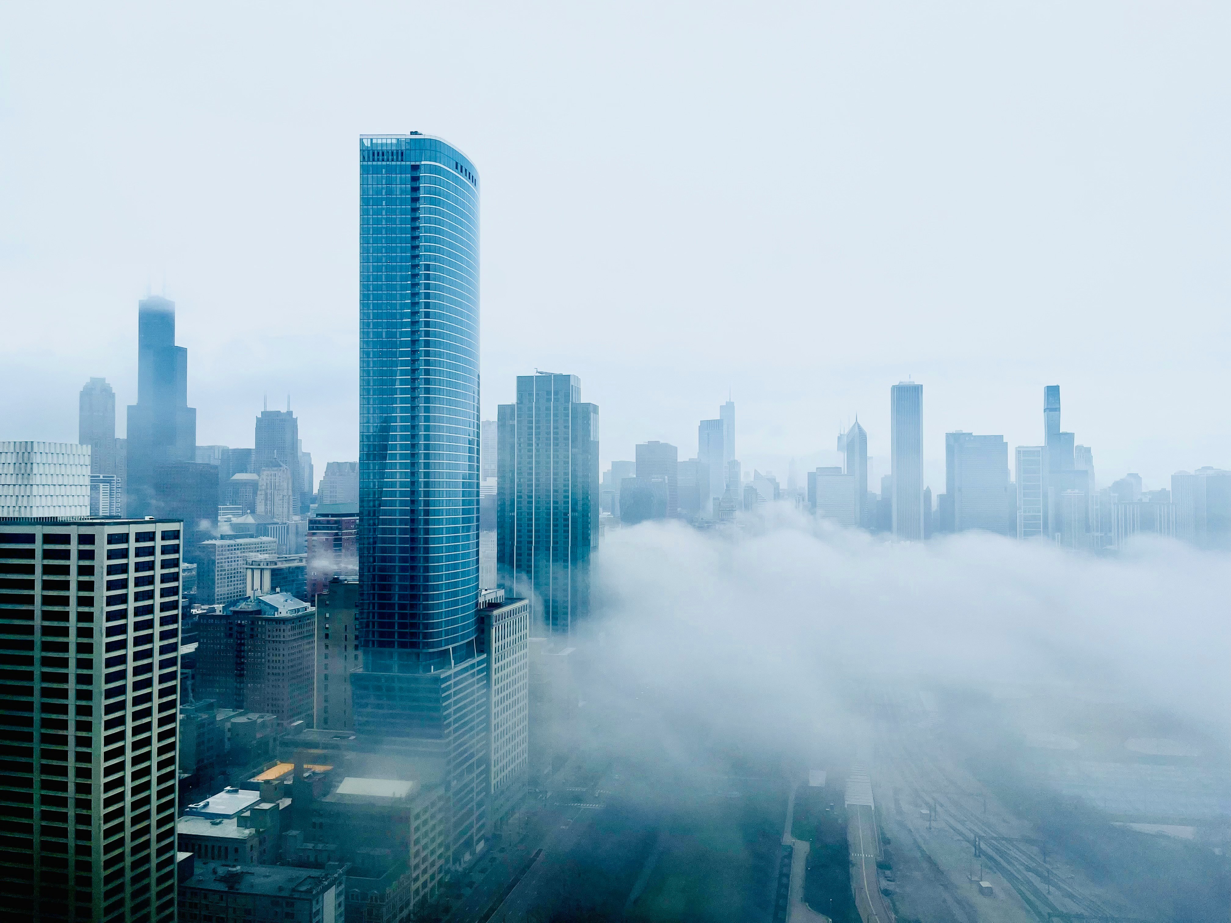 A skyline view of a city filled with tall skyscrapers partially obscured by fog.
