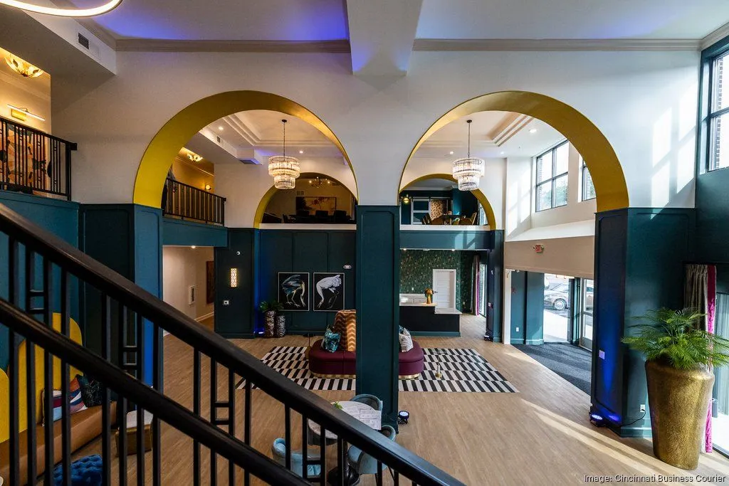 A spacious modern lobby with arched structures, colorful decor, and comfortable seating areas.