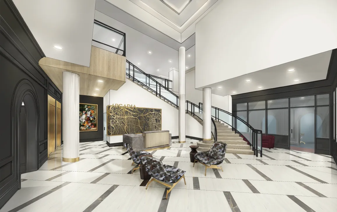 A spacious and modern lobby featuring high ceilings, elegant furniture, and a grand staircase.