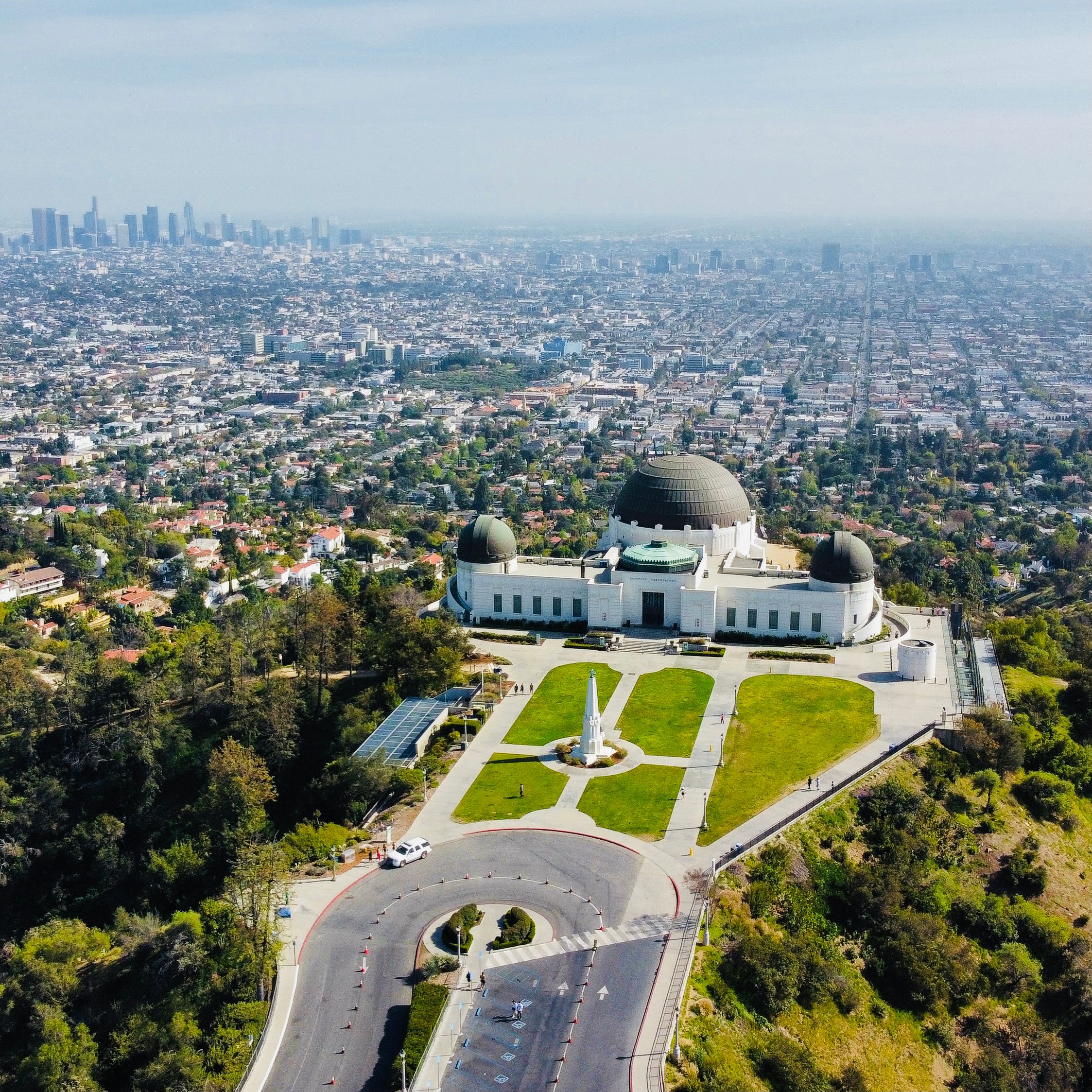 Aerial view of Griffith Observatory with city skyline in the background.