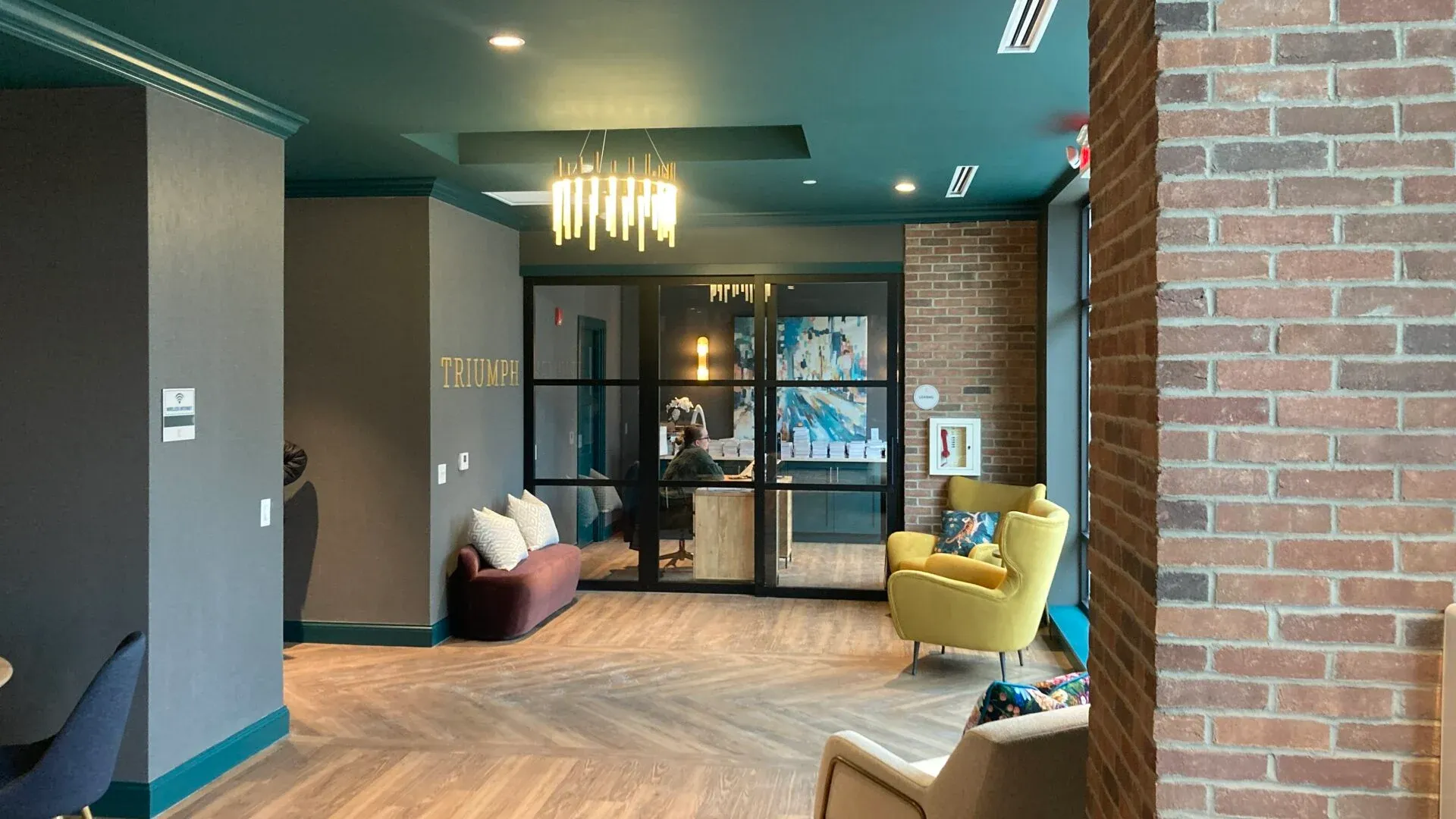 A modern community lounge area featuring stylish seating, large windows, and decorative lighting.
