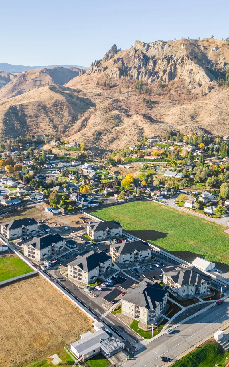 Aerial view of the Landing at Saddlerock apartment complex in Wenatchee, WA, showcasing its layout and surrounding environment, including mountains