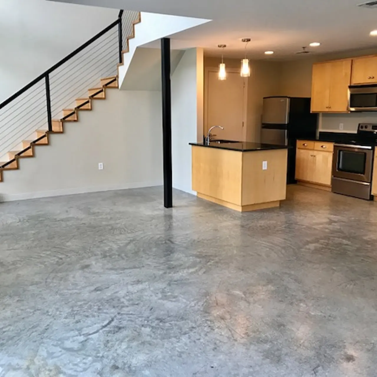 The Marquee at Belle Meade Apartments - Open Kitchen and Living Area with Polished Concrete Floors, Stainless Steel Appliances and Granite Counter Tops Throughout