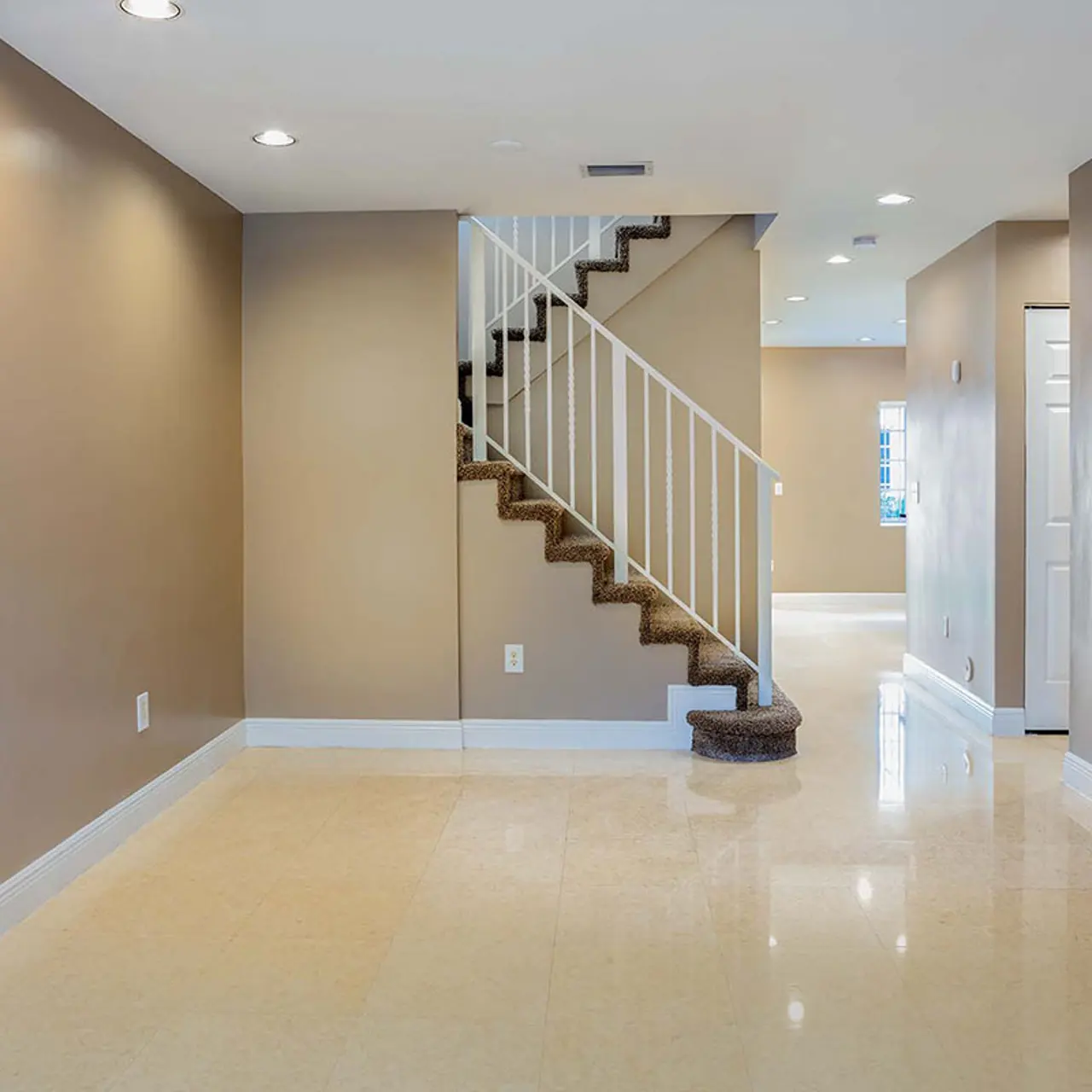 tile floored living room with carpeted stairs leading you to the second floor