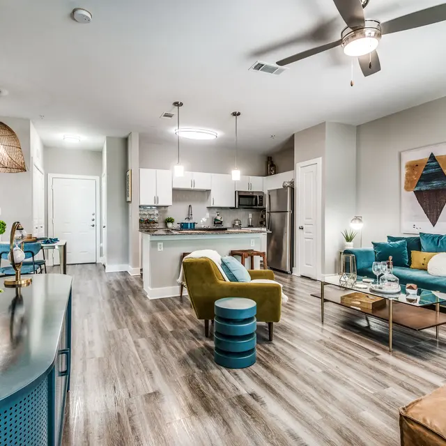 Centreport Lake Furnished model apartment on hardwood-style flooring, ceiling fan with lighting, and light gray walls.