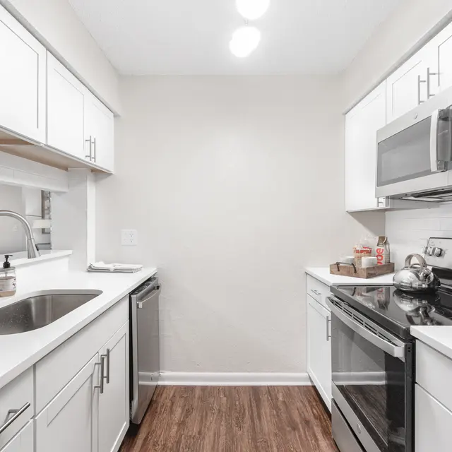 Portofino Club Kitchen with stainless steel appliances and hardwood-style flooring at Portofino Club Luxury Apartments.