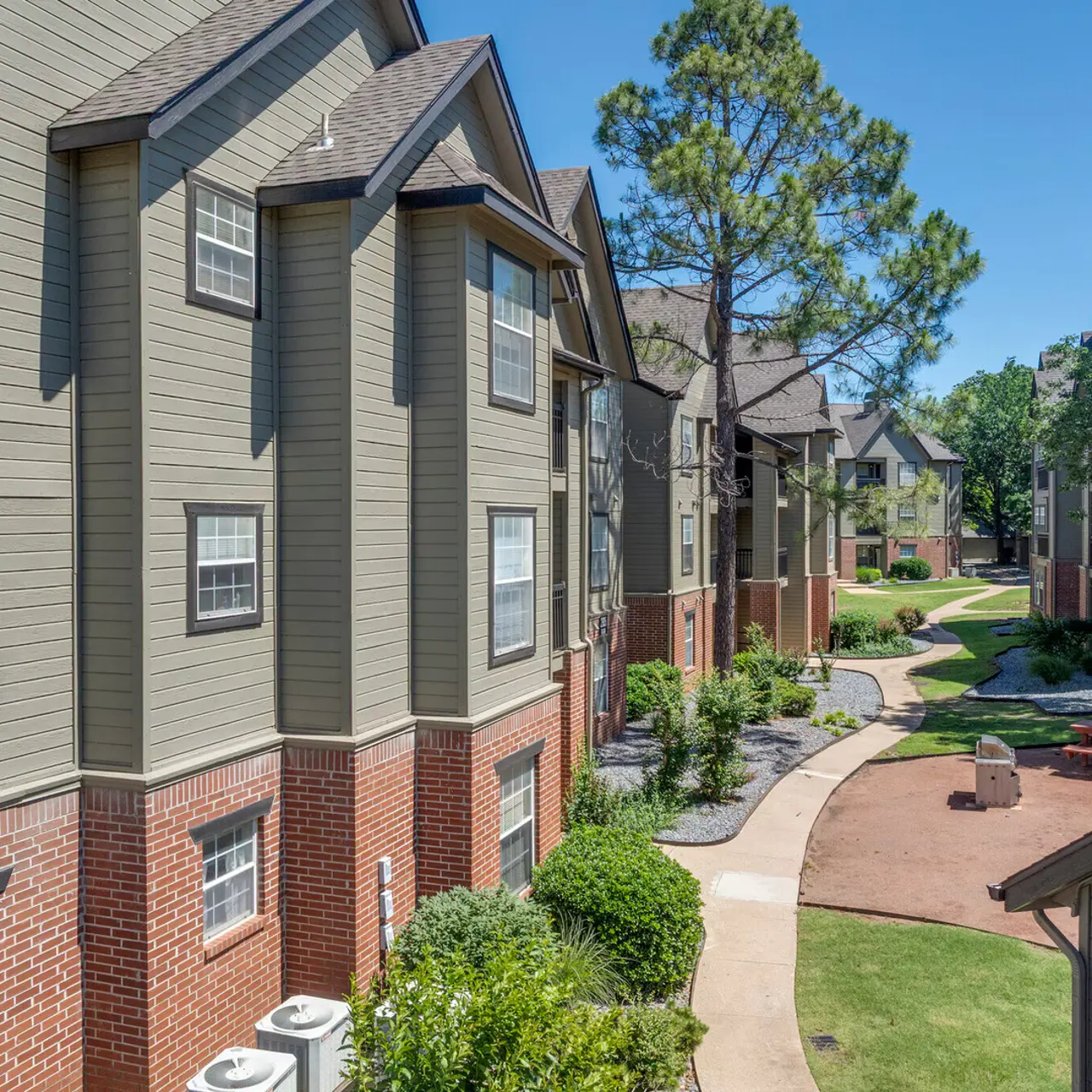 Apartment Complex Landscape View of a residential apartment complex with multiple buildings surrounded by green landscaping and pathways.