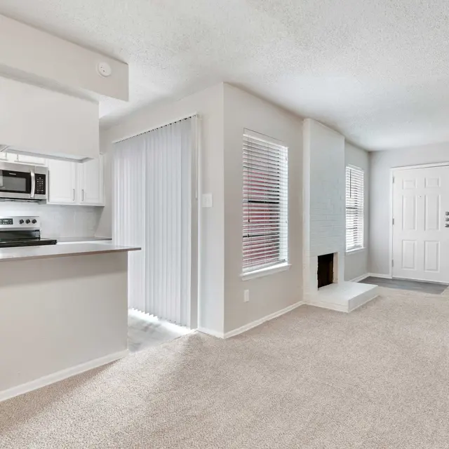 Open apartment floor plan with view into kitchen, dining, and living area with natural lighting