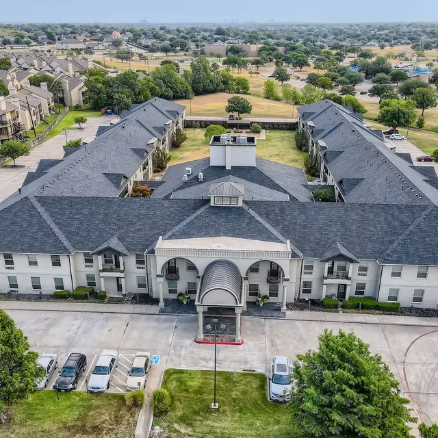 Aerial view of a multi-building apartment complex surrounded by greenery.