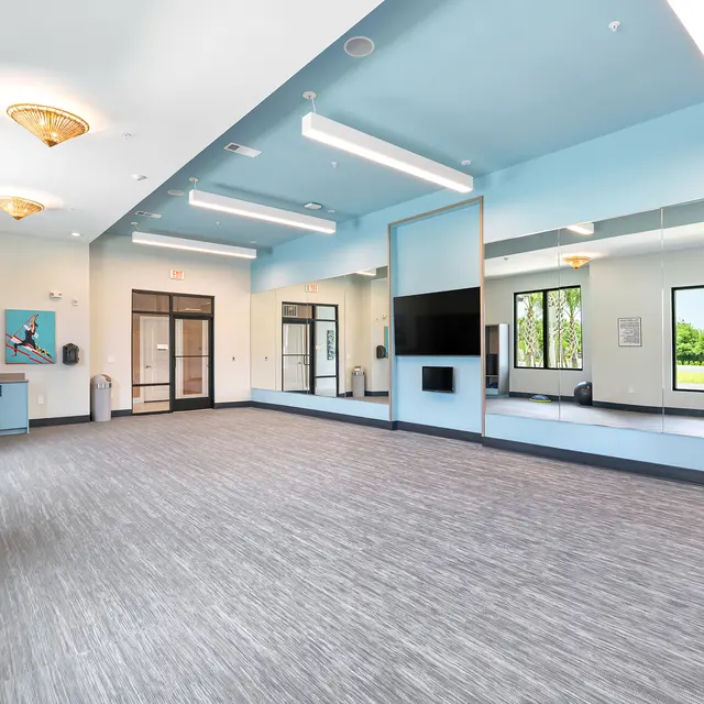 Spacious Modern Indoor Room A spacious, modern indoor room featuring large windows, light blue walls, and ample floor space.