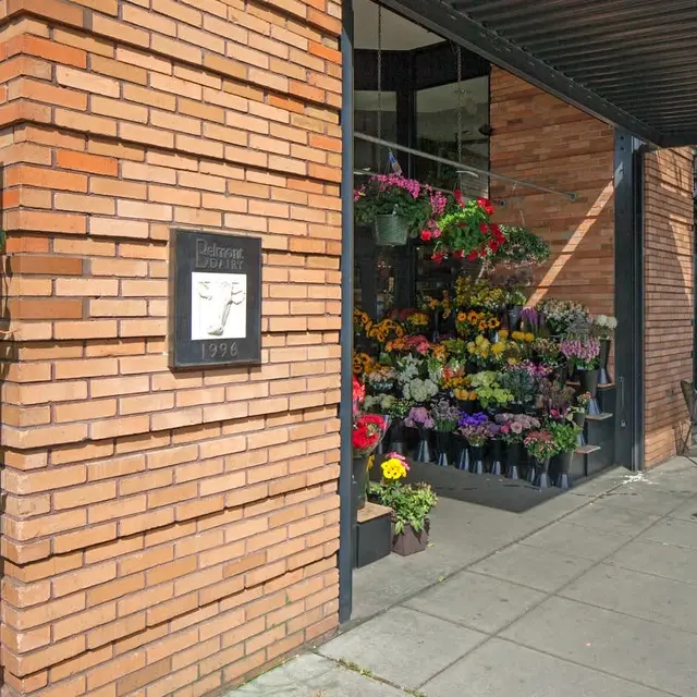 Exterior view of a flower shop with a variety of colorful flowers displayed.