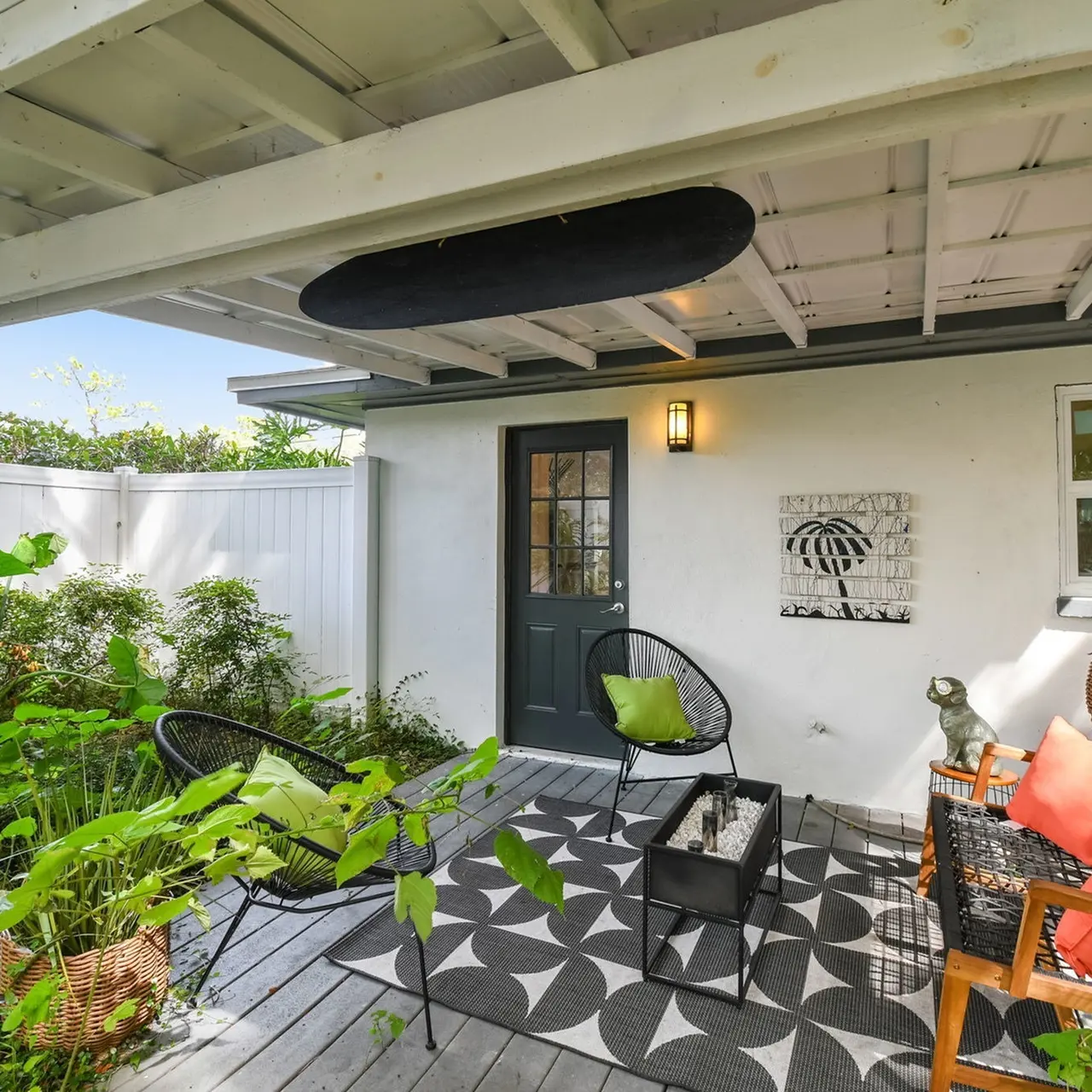 Porch area of an apartment, fitted with chairs, a table, and a high ceiling