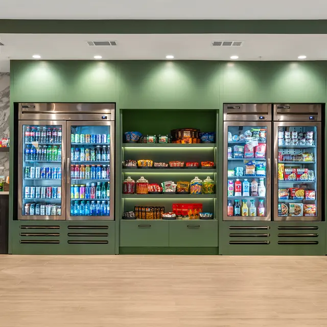 A modern convenience store display featuring multiple refrigeration units and shelves filled with various products.