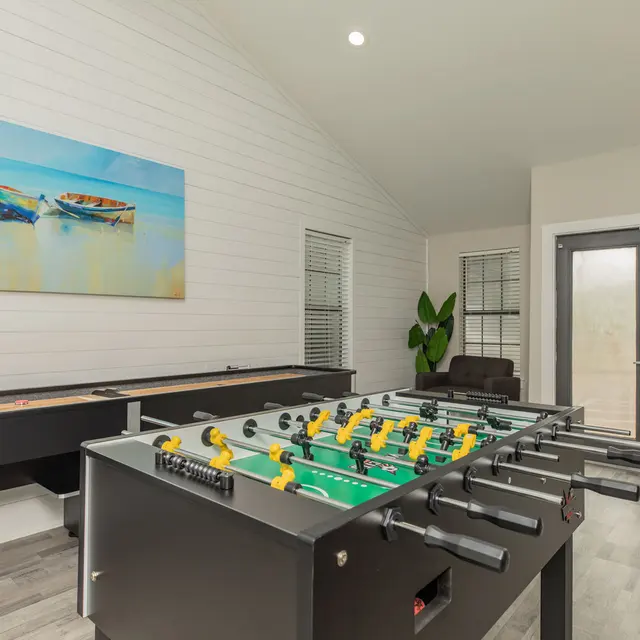 Artisan at South Lamar Game room at Artisan at South Lamar in Austin, TX featuring foosball and shuffleboard tables with modern decor and natural light