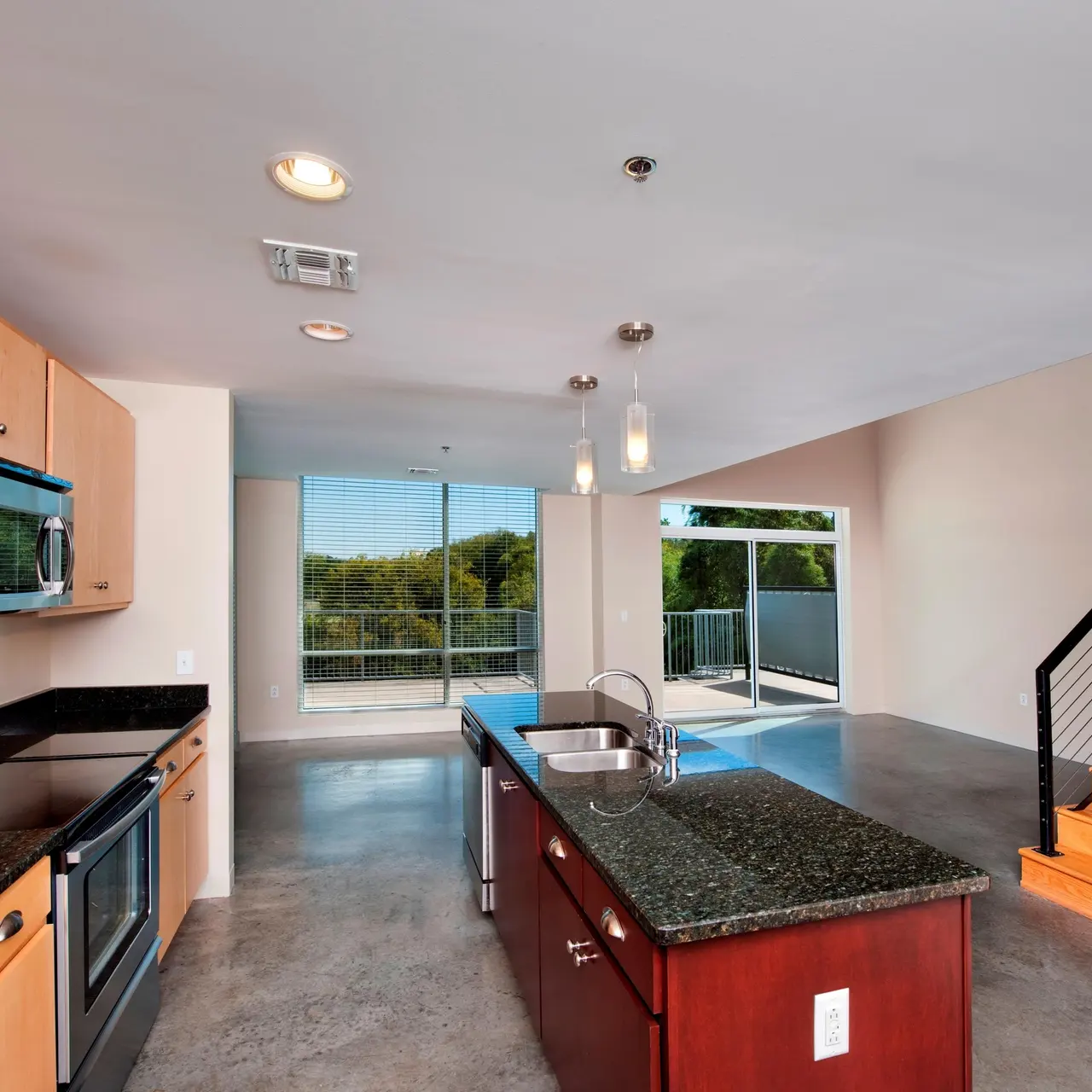The Marquee at Belle Meade Apartments - Open Kitchen and Living Area with Polished Concrete Floors, Stainless Steel Appliances and Granite Counter Tops Throughout