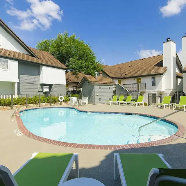 Edge Studios resident pool with green lounge chairs and seating with resident buildings in the background