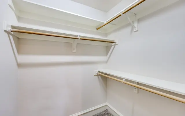 Empty Closet with Shelves An empty closet with white walls and wooden shelves.