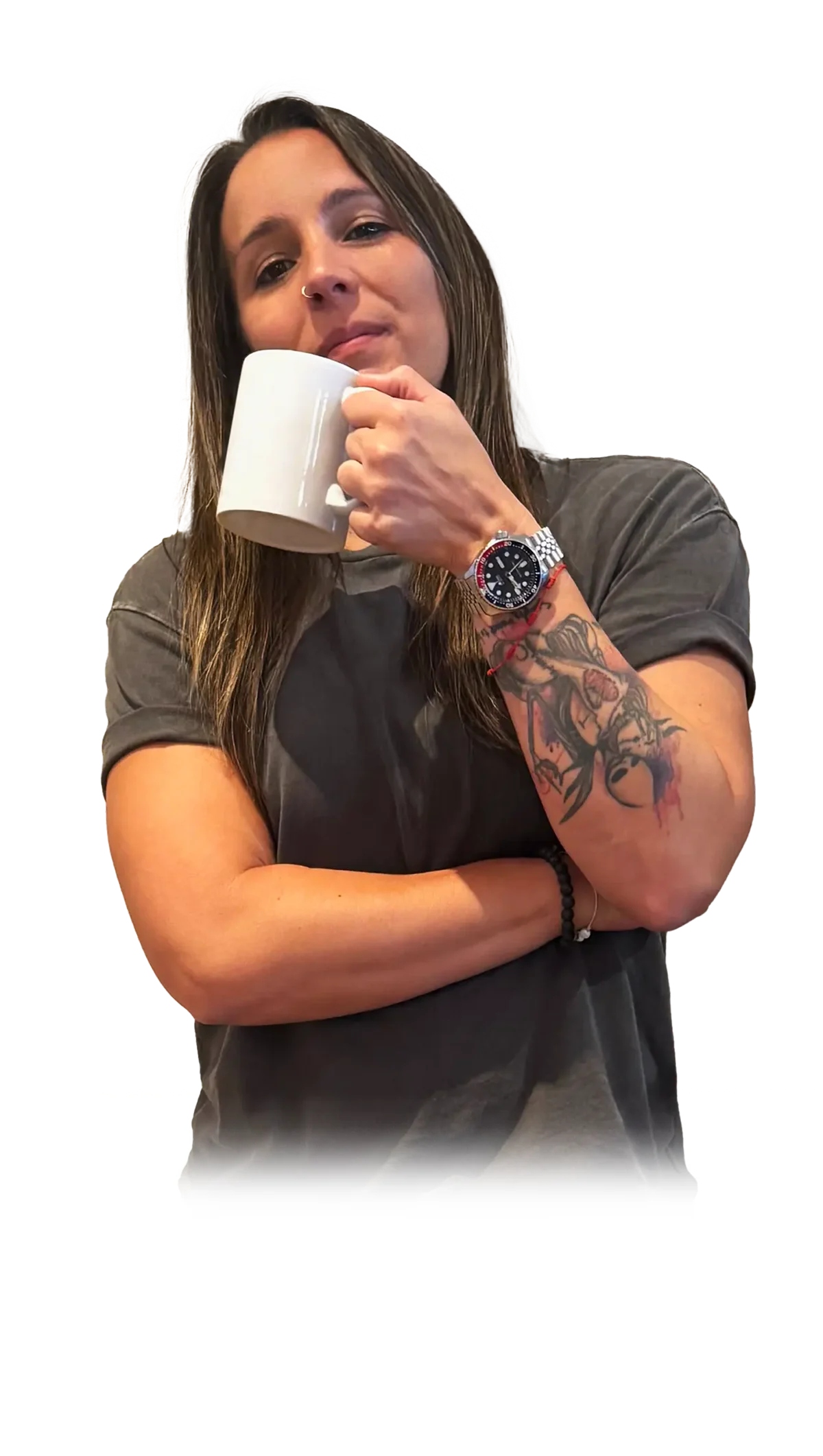 Casual Portrait with Mug A person with long hair and a tattoo holding a white mug, posing confidently with crossed arms.