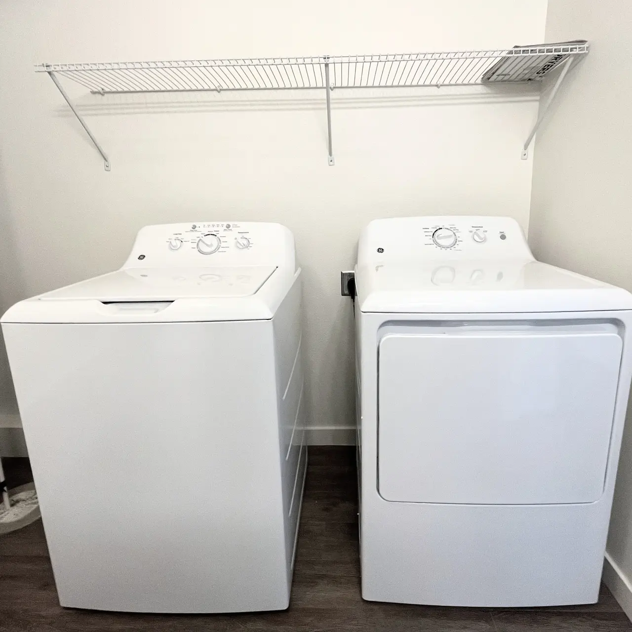 apartment full size washer dryer The front view of a modern washer and dryer set in a laundry room, featuring storage space