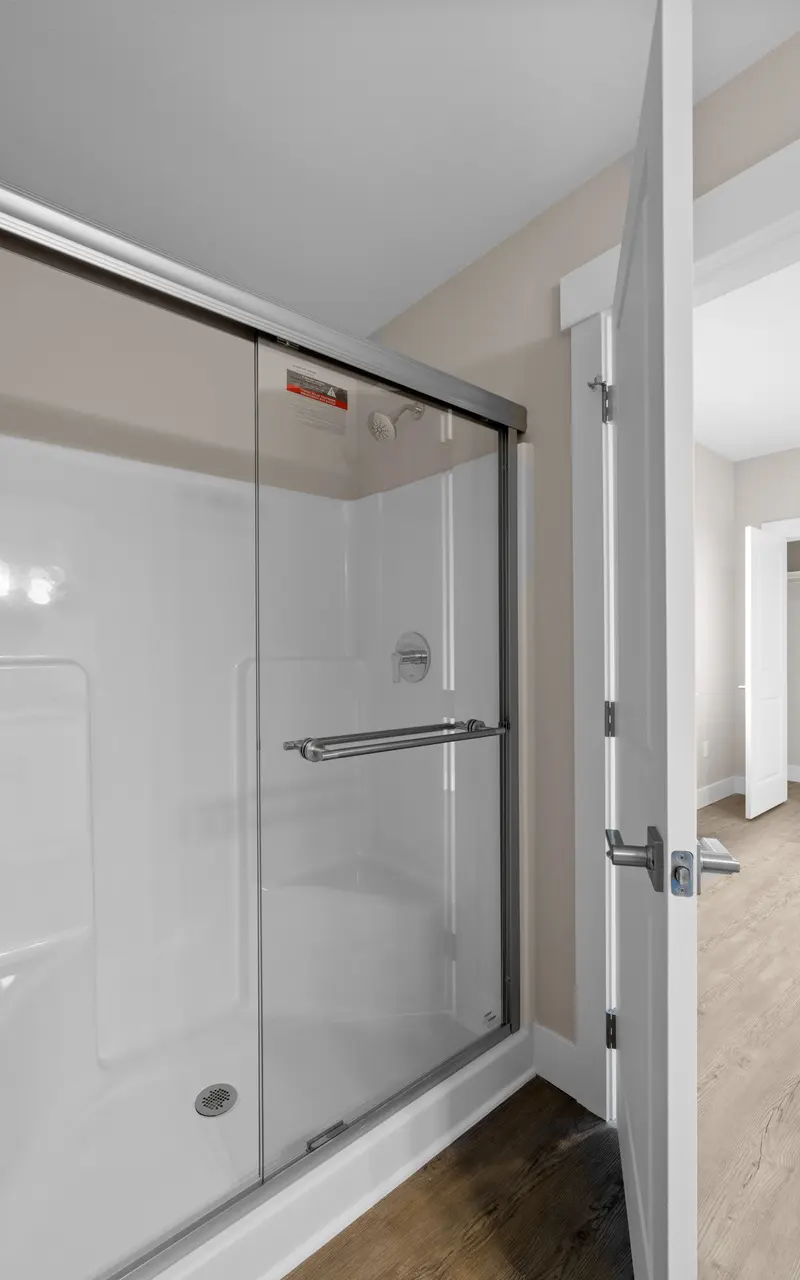 Modern walk-in shower with sleek glass doors, featuring a spacious interior for a luxurious bathing experience