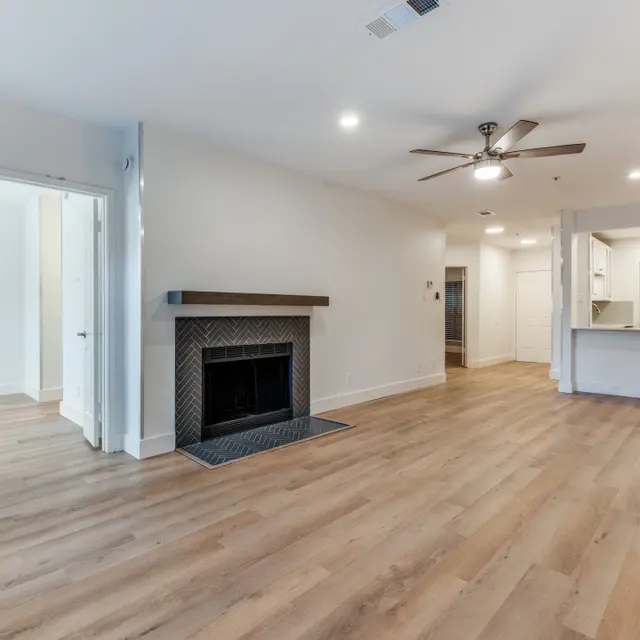 Spacious modern living room with hardwood floors and a fireplace