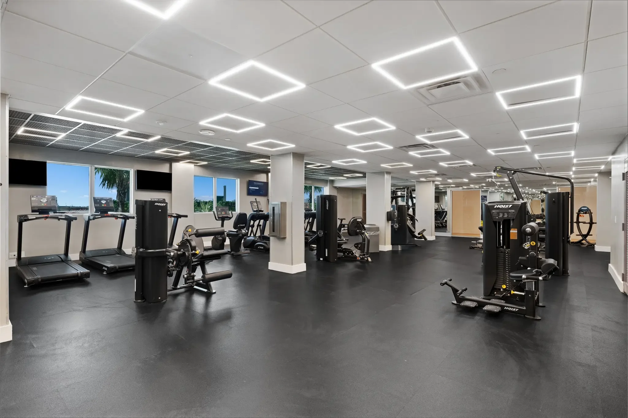 Modern Gym Interior A modern gym interior featuring workout machines, treadmills, and large windows with a view.