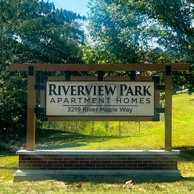 A sign for Riverview Park Apartment Homes displaying the address.