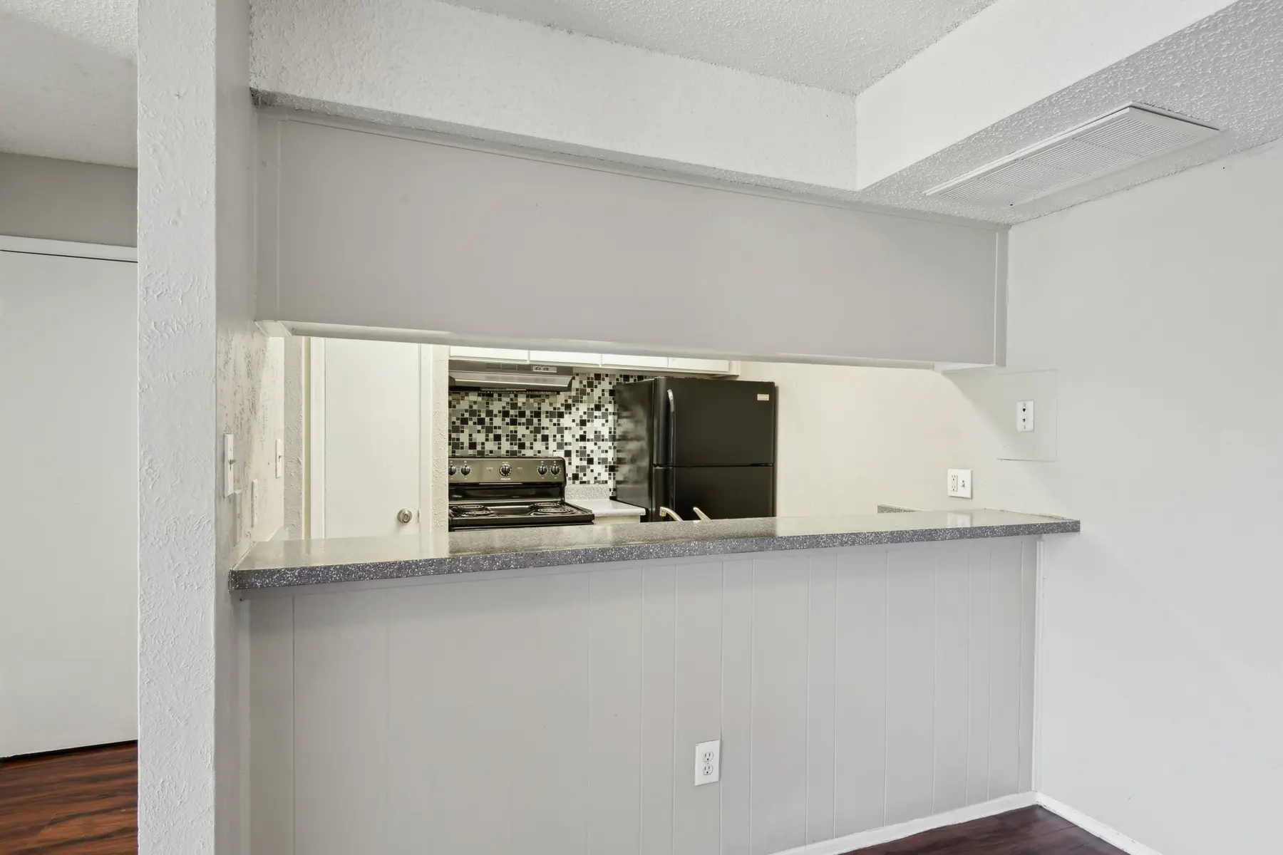 Modern kitchen view with black appliances and a decorative backsplash