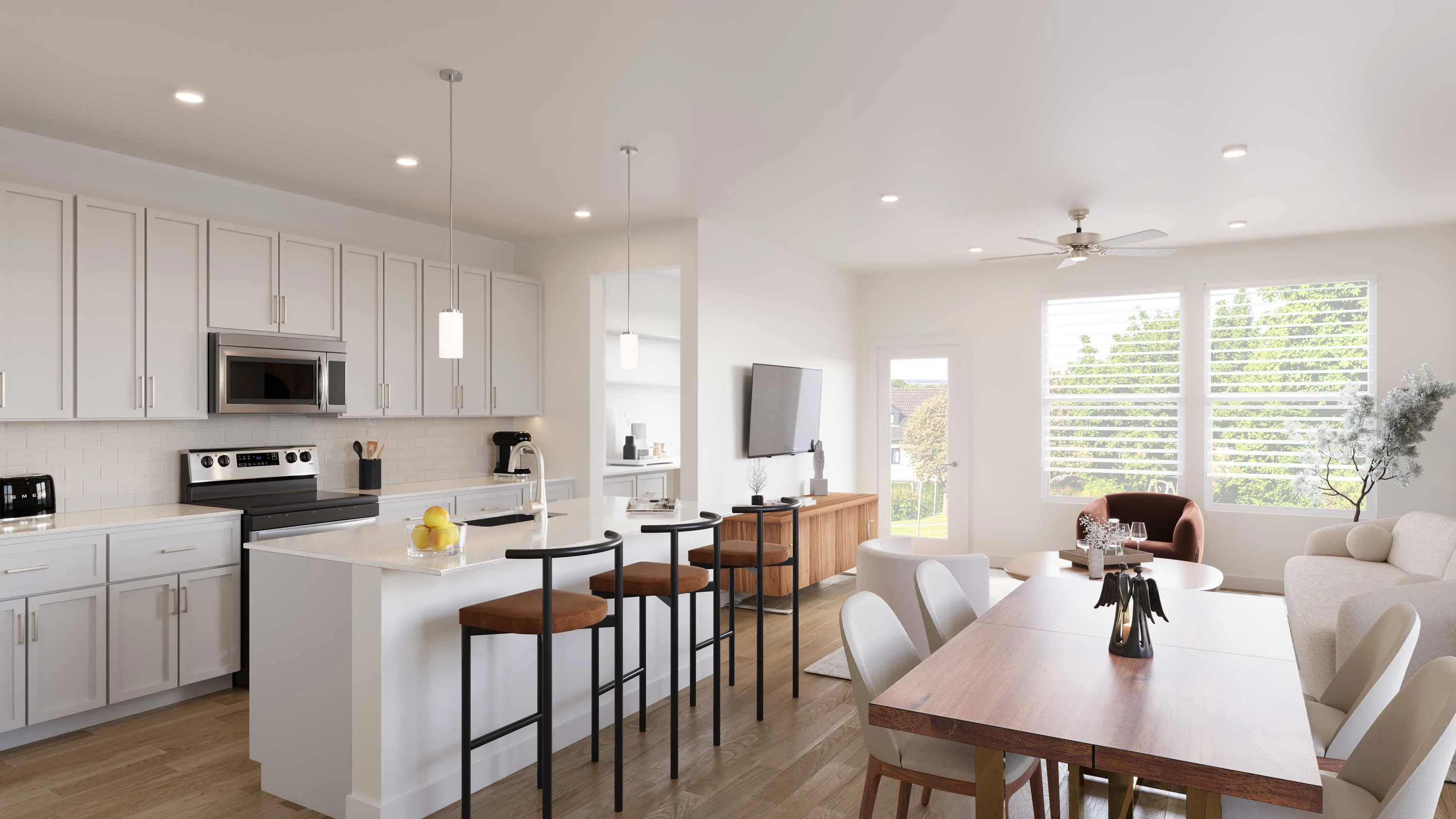 A modern kitchen and living room area featuring a white cabinetry kitchen with an island, bar stools, dining table, and a sofa in a well-lit open-plan layout.