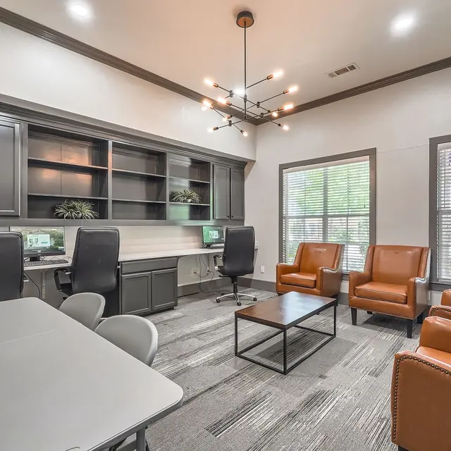 Interior view of a modern office space with desks, chairs, and windows.