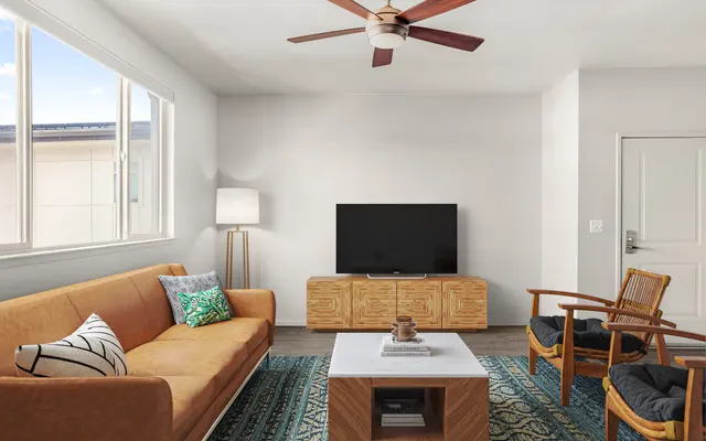 living room area with TV, coffee table, seating, ceiling fan, and window at apartments in Kapolei, HI - Ceiling Fan, Appliance, Living Room