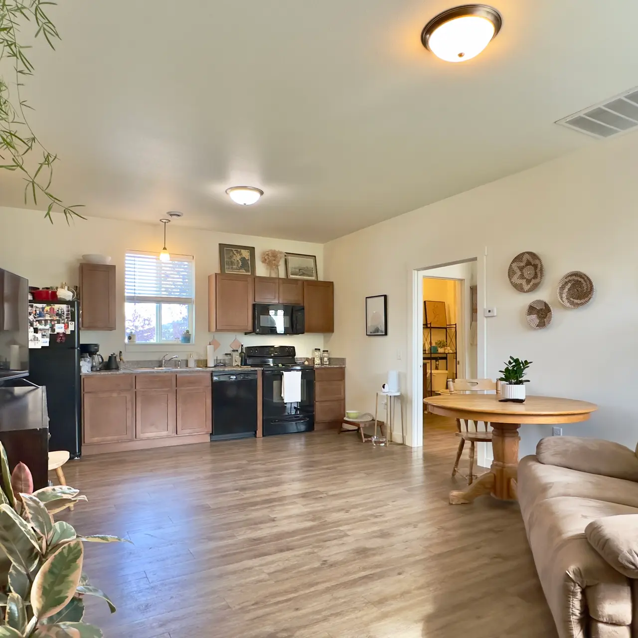 apartment living room A living and dining room in the apartment, furnished with a sofa, console table and television, bookshelf, dining table, and elegant decor, offering a comfortable and inviting setting