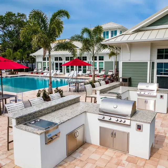 ShoreView Two large outdoor grilling stations with bar seating near the swimming pool and clubhouse at ShoreView Waterfront Apartments.
