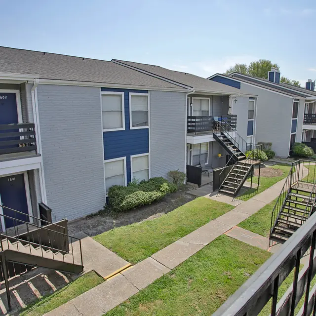 Apartment Complex Overview View of an apartment complex showing two-story buildings with balconies and green lawn areas.
