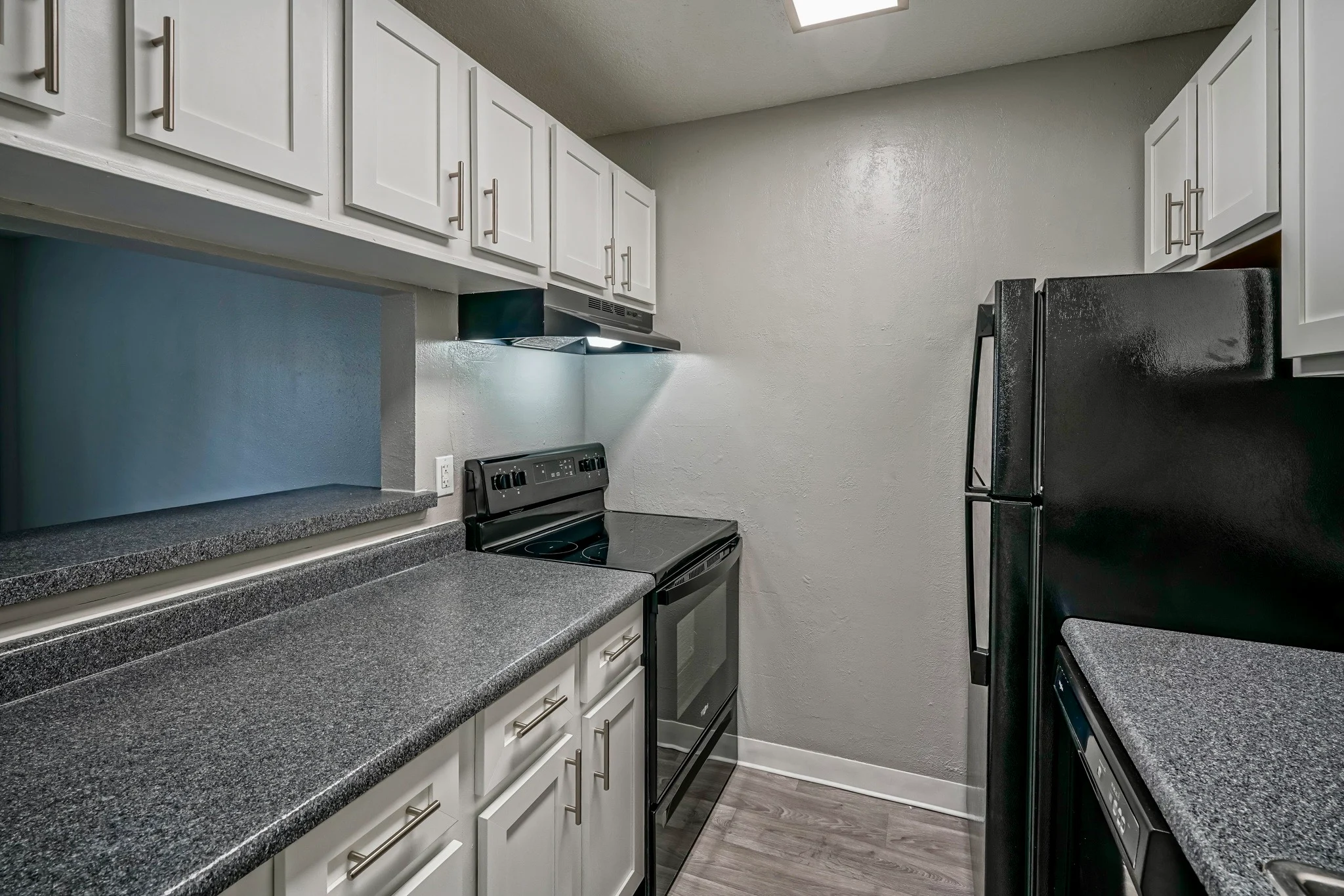 Modern Kitchen Interior A modern kitchen featuring white cabinets, dark countertops, and stainless steel appliances.