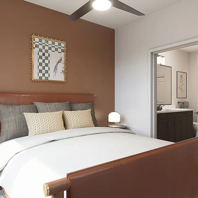A modern bedroom featuring a brown accent wall, a textured headboard with decorative pillows, and a cozy white bedspread. Soft lighting is provided by bedside lamps, and a view of a bathroom is visible through an open door.