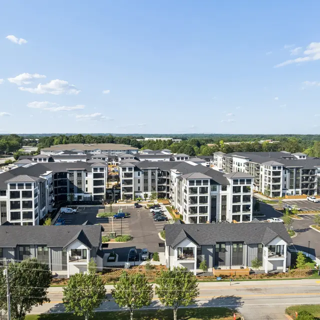 Aerial View of Modern Apartment Complex Aerial view of a modern apartment complex with multiple buildings, parking areas, and landscaped greenery.