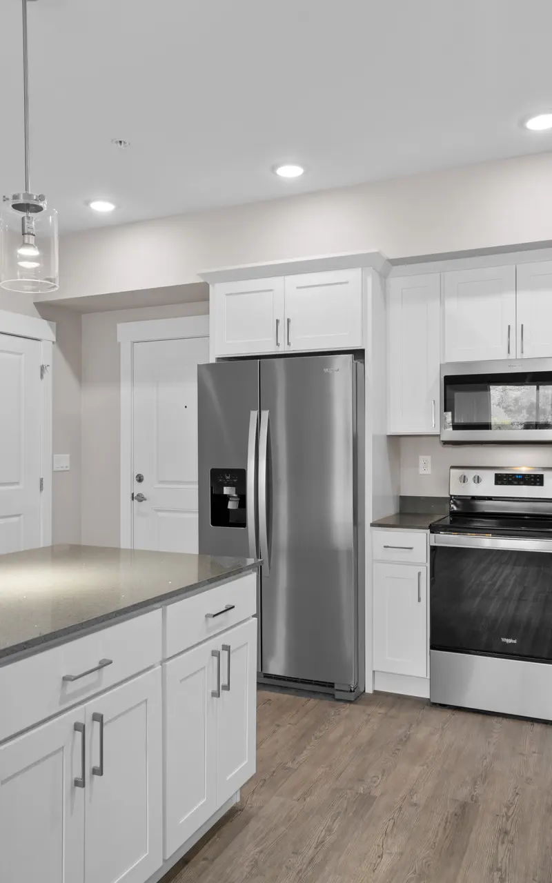 Modern kitchen in an apartment with stainless steel appliances and stylish finishes with a central island, large countertop, built-in sink, providing a functional and stylish workspace