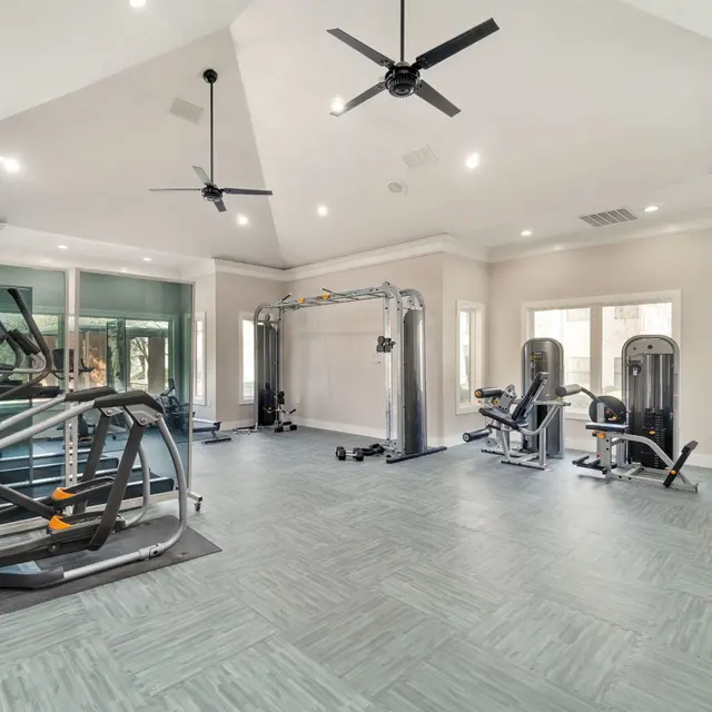 Arboretum at Lewisville's fitness center with high ceiling fans, vinyl flooring, and both muscle and cardio equipment for use.