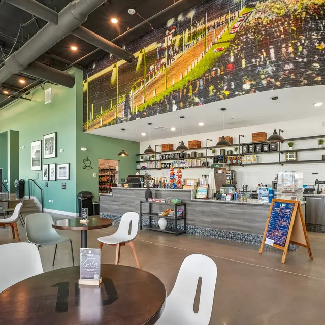Modern Coffee Shop Interior Interior of a modern coffee shop with a large mural, a counter with various products, and seating areas.