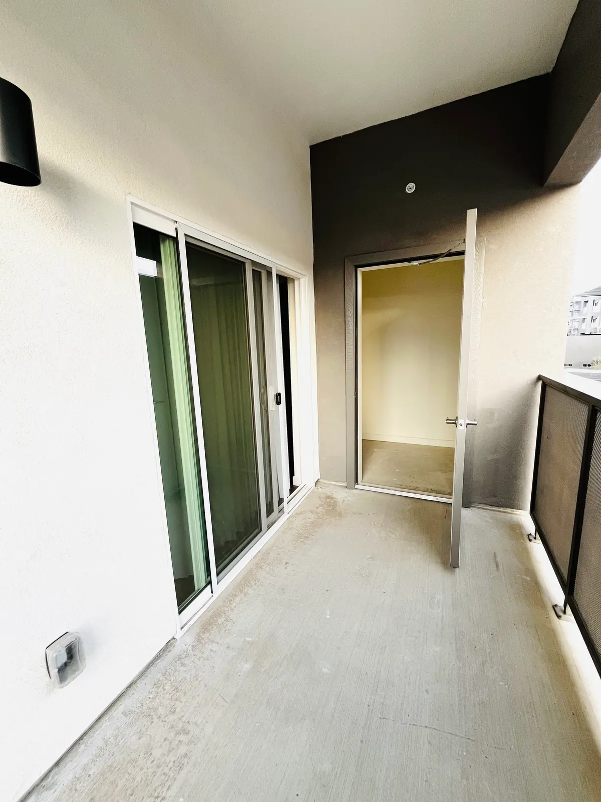 Covered outdoor space beside a sliding glass door and storage doorway.