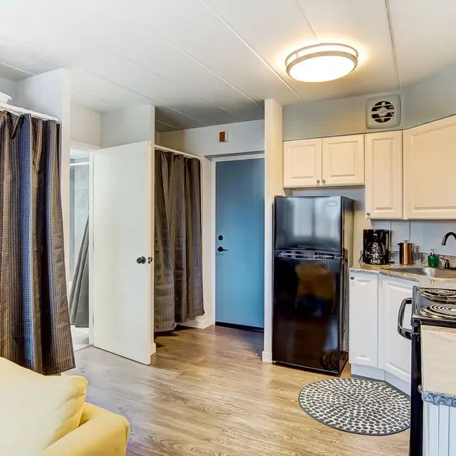 Compact kitchen and living area in an apartment with yellow chair