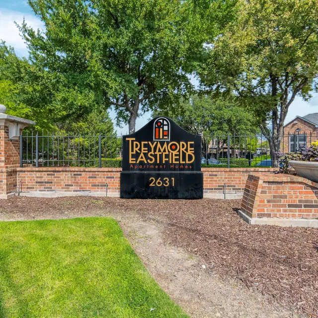 Sign for Treymore at Eastfield apartment community, displaying the name and address at a landscaped entrance.